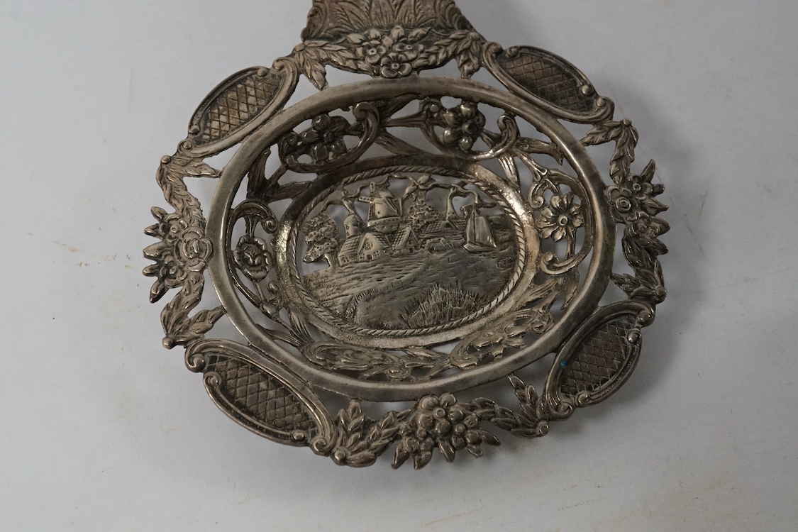 A late 19th century German pierced 800 standard white metal mounted liqueur jug, stamped Kremos, 14.4cm, a 19th century Dutch embossed 830 standard white metal trinket box and an Edwardian Hanau silver tea strainer, impo